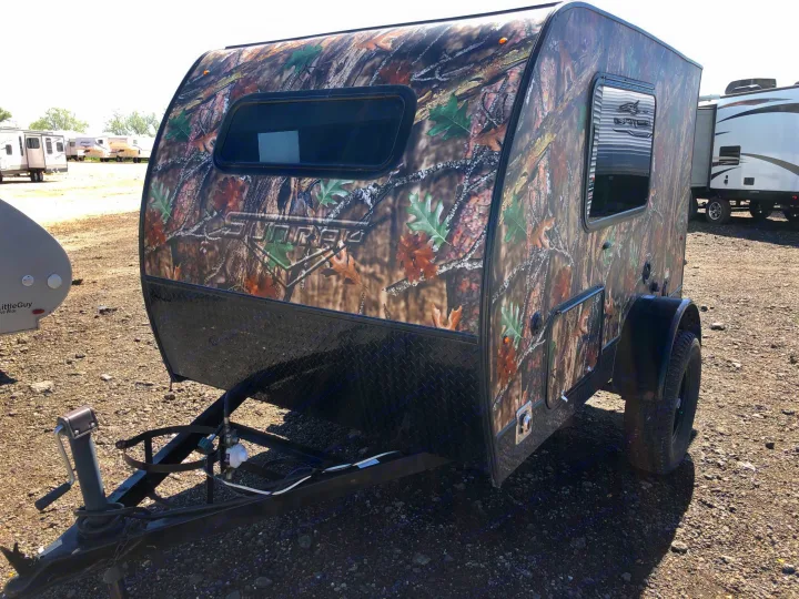 A compact, camouflaged teardrop camper for RV rental, parked on gravel with other RVs in the background.. Sunset Park & Rv Inc. Other 2017