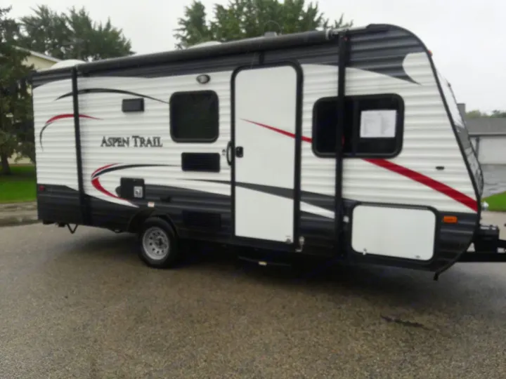 Aspen Trail travel trailer, perfect for your next RV rental adventure. White and black RV with awning.. Keystone ASPEN TRAIL 1700 2016