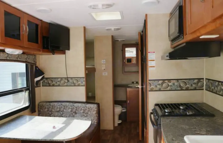 Spacious RV rental interior featuring kitchen, dining area, bathroom, and bunk beds. Perfect for family adventures.. Keystone Passport 2014