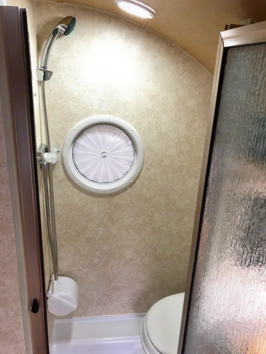 RV rental bathroom: Efficient space with a shower, toilet, and distinctive circular window, optimized for compact living.. T@B Other 2019