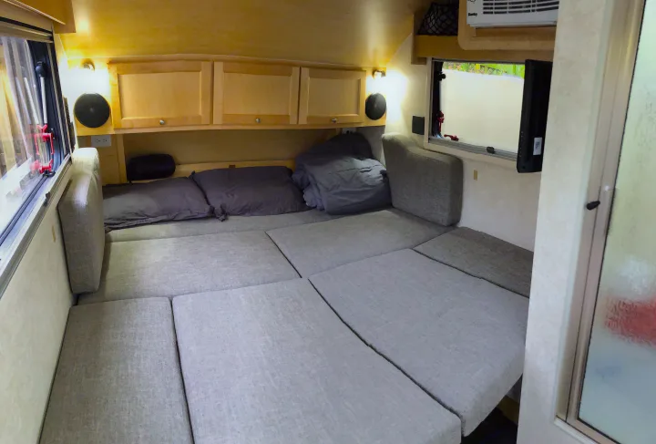 RV rental: Compact interior showing a comfy convertible bed, wood cabinets, and air conditioning unit. Ready for adventures!. T@B Other 2019