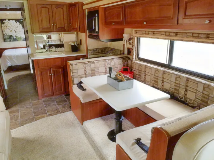 Dining table with wrap around seating and the kitchen beyond that.. Winnebago Vista 2011