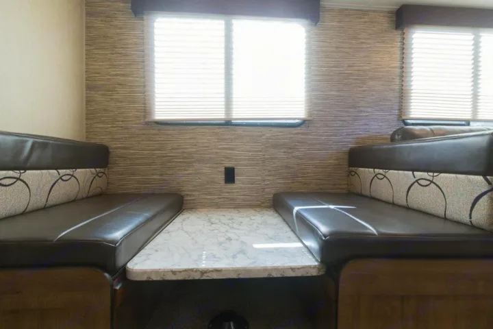 Enjoy this RV rental's cozy dinette with spacious brown benches, a marble-look table, and large windows with blinds.. Gulf Stream Kingsport 2019