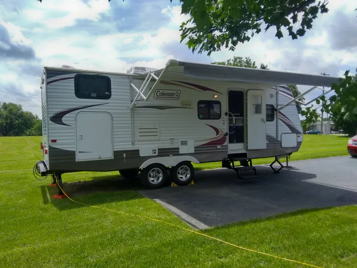 Exterior Entry side with a porch light, Exterior power outlet, 3 step entry with gold away grab assist handle, and a large power retractable awning to provide shade from the sun and protection from the rain.. Dutchmen Coleman 2010