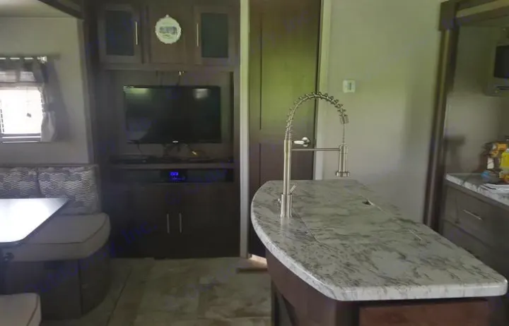 Spacious RV rental interior: modern kitchen island, entertainment center with TV, and comfortable dinette. Your home away from home.. Forest River Surveyor 2018