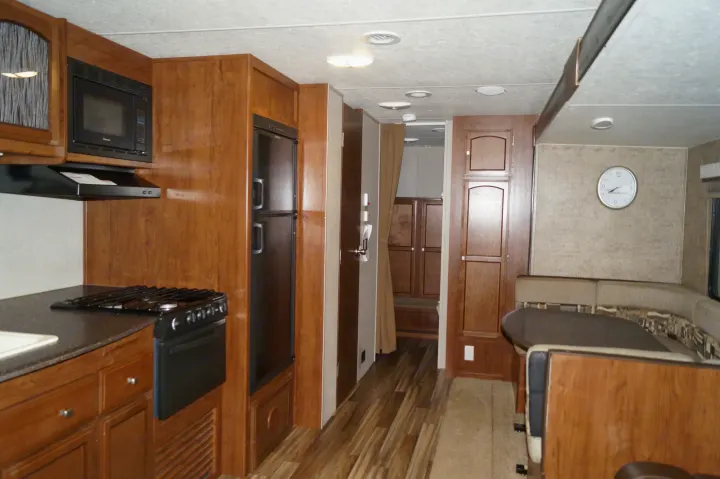 Step inside this RV rental, showcasing a functional kitchen with wood cabinetry, appliances, and a comfortable dining area.. Coachmen Freedom Express 2018