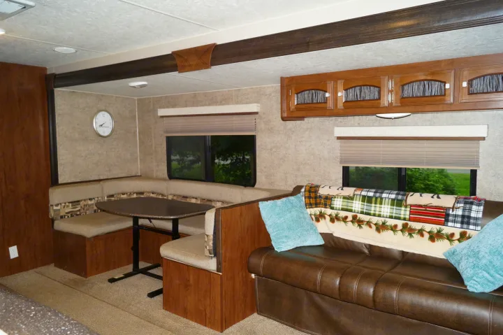 Enjoy the comfortable dinette & sofa in this RV rental's cozy interior, complete with cabinets & windows.. Coachmen Freedom Express 2017