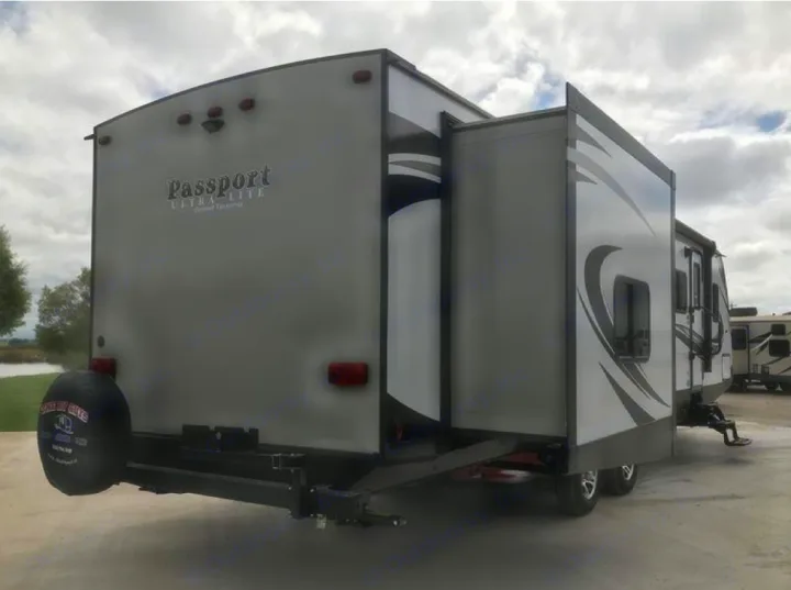 This gray Passport Ultra Lite RV rental, featuring an extended side slide-out and rear spare tire, is ready for adventure.. Keystone Passport 2019