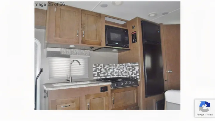 Inside this RV rental, a compact kitchen with sink, microwave, stove, and refrigerator.. Winnebago Outlook 2019
