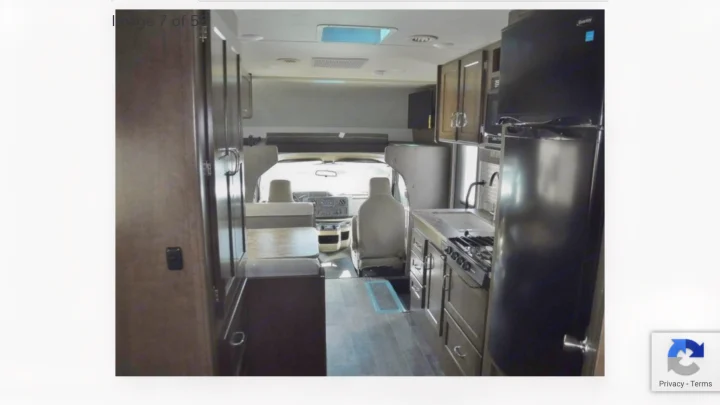 Spacious rv rental interior featuring a full kitchenette with fridge and stove, dining area, and front cabin view. Ideal for travel.. Winnebago Outlook 2019