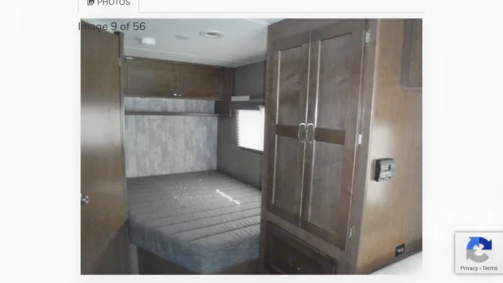 RV rental bedroom: grey mattress, overhead cabinets, and wardrobe storage in a compact, functional space.. Winnebago Outlook 2019
