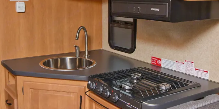 An RV rental's practical galley features a sink, faucet, and two-burner stove. Ideal for on-the-road cooking.. Other Other 2015
