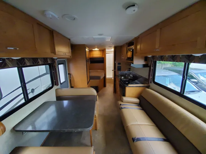 Spacious RV rental interior with kitchen, dinette, sofa with seatbelts, and rear bed/bathroom, offering comfortable travel.. Winnebago Minnie Winnie 2018