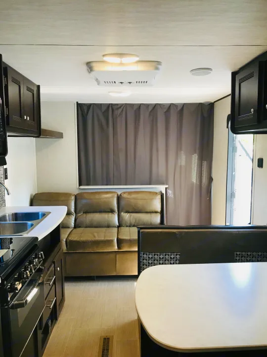 Inside this RV rental: full kitchen with stove, comfortable sofa, and a dinette area. Ready for your next adventure.. Heartland Prowler Lynx 2019