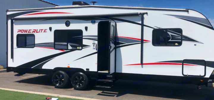 White Powerlite RV rental, a travel trailer, with striking black/red graphics, open side door with steps, and dark wheels.. Pacific Coachworks Other 2019
