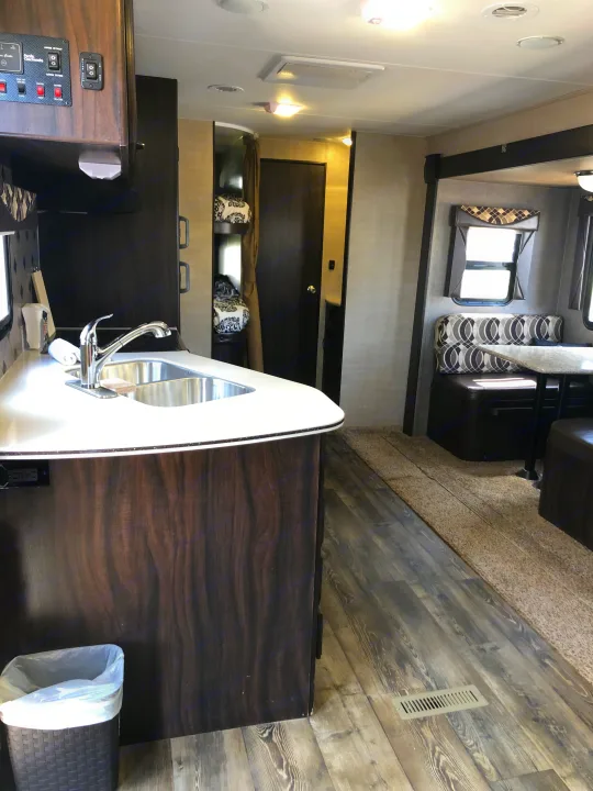 RV rental interior: A bright, modern living space with kitchen, dining booth, and bunk beds visible.. Pacific Coachworks Panther BHSS 2019