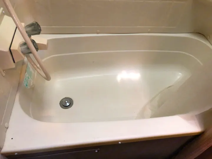 Inside an RV rental: a compact, white bathtub/shower with controls and drain. Practical for on-the-go living.. Pacific Coachworks Panther BHSS 2019