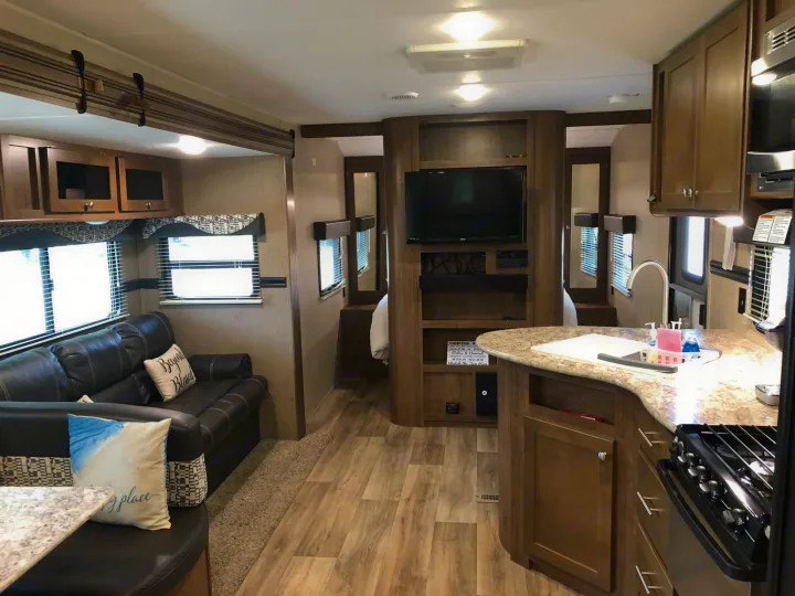 Comfortable RV rental interior: living area, kitchen, TV, and dining. Ideal for travel and adventure.. Dutchmen Aspen Trail 2018