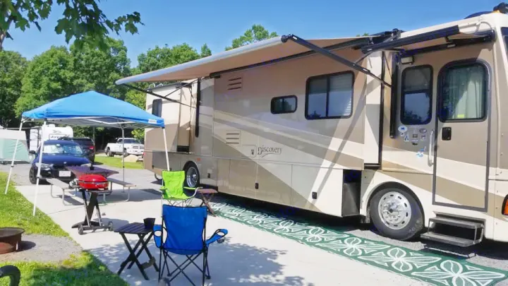 Set up at camp ground with grill and chairs with awnings out.. Fleetwood Discovery 2006