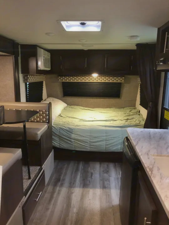 Cozy RV rental camper interior with bed, dinette, and compact kitchen. Ideal for travel trailer adventures.. Jayco Other 2020