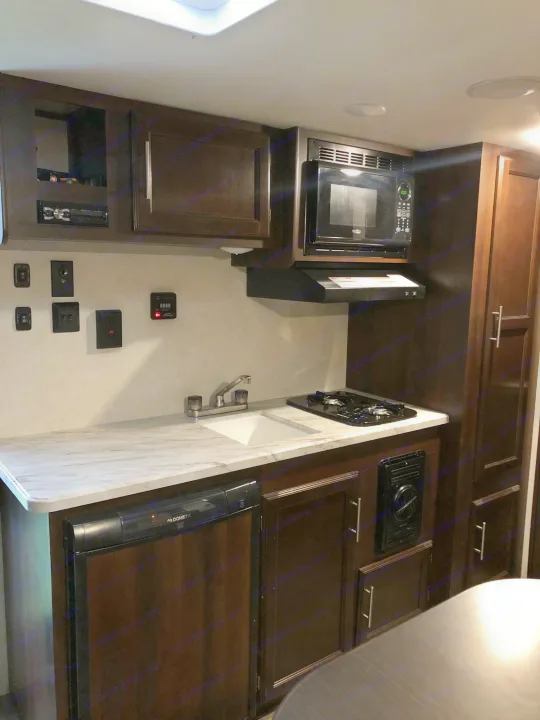 Compact RV rental kitchen features a sink, 2-burner stove, microwave, and Dometic fridge for convenient travel.. Jayco Other 2020