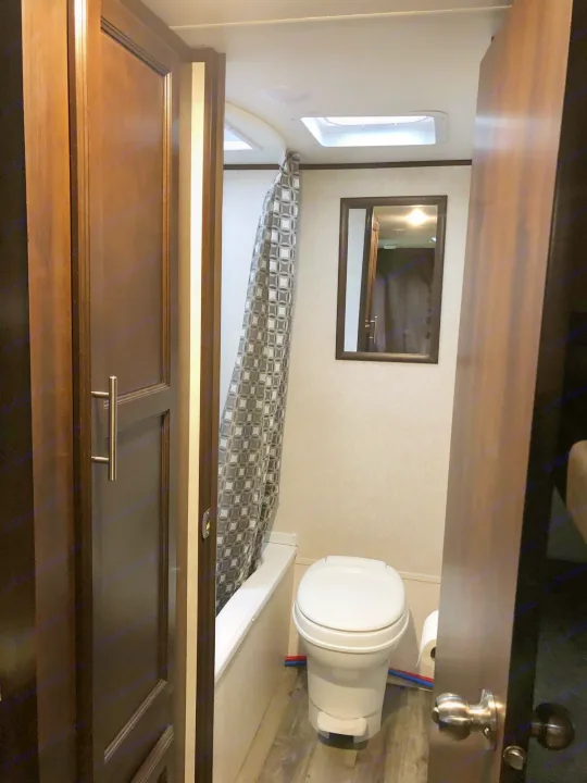 RV rental bathroom: Compact space with toilet, shower, mirror, and skylight, ideal for your adventures.. Jayco Other 2020