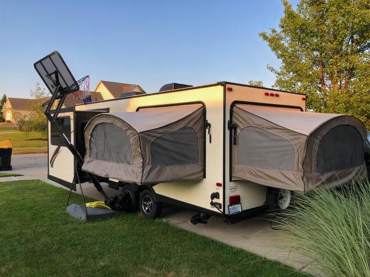 Spacious hybrid RV rental with both tent sections extended, ready for a trip! Parked in a sunny residential driveway.. Dutchmen Kodiak 2016