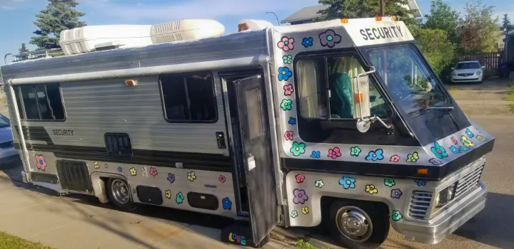 Unique custom RV rental: A grey motorhome with black accents & colorful floral decals. "SECURITY" is visible.. Chevrolet Other 1980