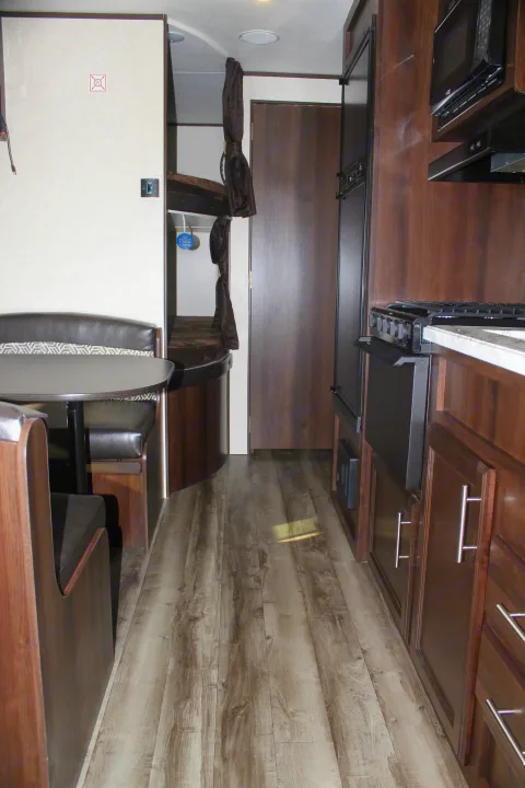 Inside an RV rental: a comfortable dinette, practical bunk beds, and a fully equipped kitchen with wood floors.. Jayco Jay Flight SLX 2019