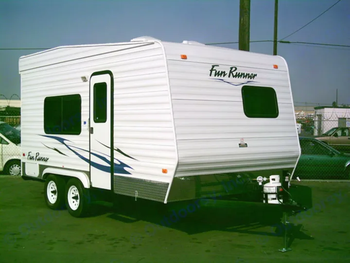 White Fun Runner travel trailer RV rental, featuring a side door, windows, and dual axles.. Carson Trailer Toy Hauler 2007