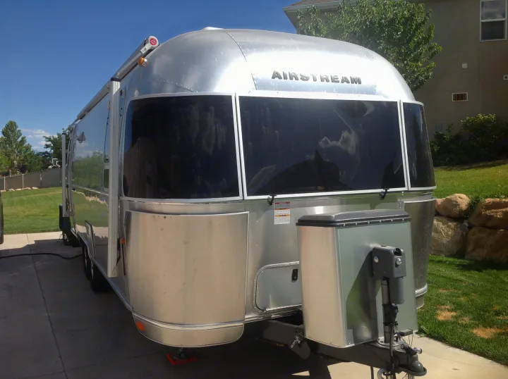 A polished silver Airstream travel trailer, suitable for RV rental, parked on a sunny driveway.. Airstream International 2015