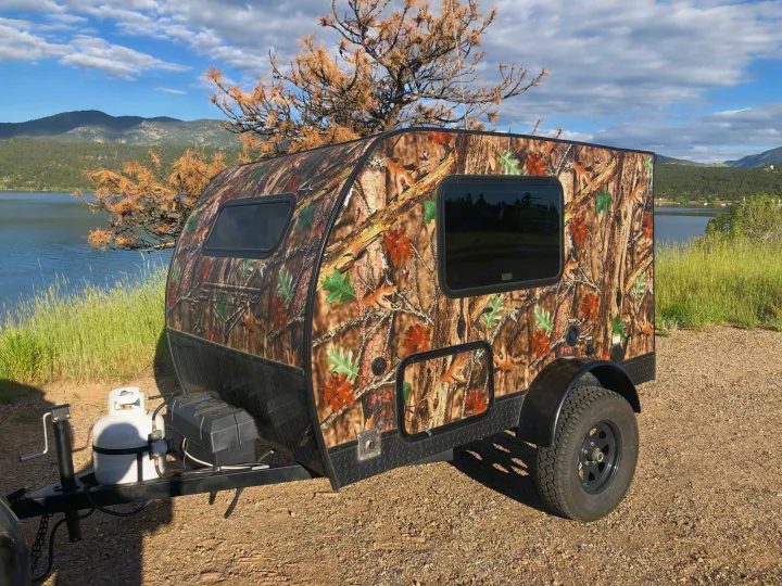 Camouflage teardrop camper RV rental by a lake and mountains. Ideal for off-road outdoor adventures.. Sunset Park & Rv Inc. Other 2017