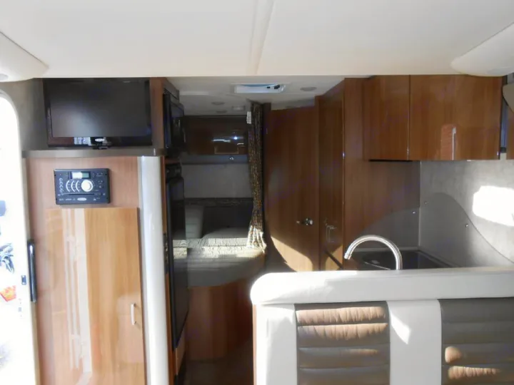 Inside this rv rental: a well-equipped kitchen, TV entertainment, and sleeping area with bunk beds visible.. Winnebago Trend 2016