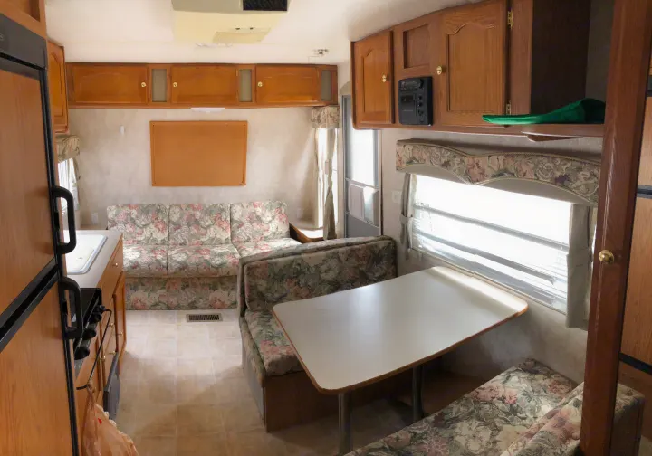 Inside this RV rental: a well-equipped kitchen, floral sofa, dinette, and overhead cabinets offer a homey travel space.. Keystone Springdale 2004