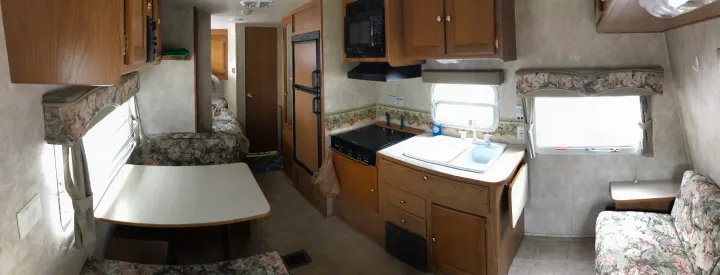 Inside a well-equipped rv rental: dinette, kitchen (sink, stove, microwave, fridge), bedroom, and sofa lounge area.. Keystone Springdale 2004