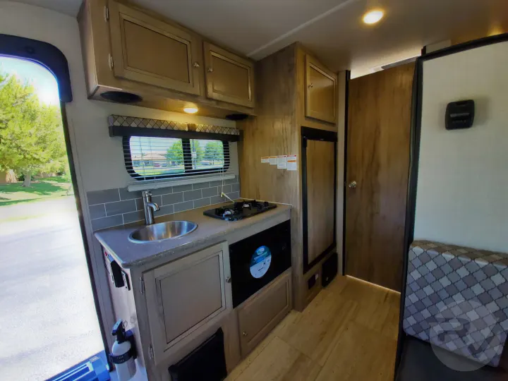Step inside this RV rental! Features a compact kitchenette with sink, stove, and refrigerator, plus ample storage.. Palomino Palomini 2020