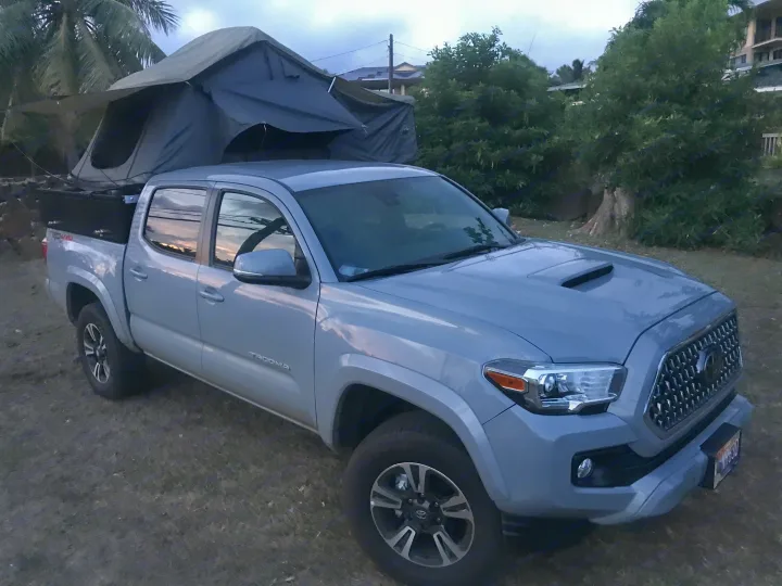 This grey Tacoma pickup with a rooftop tent makes for a unique RV rental, perfect for outdoor adventures.. Other Other 2019