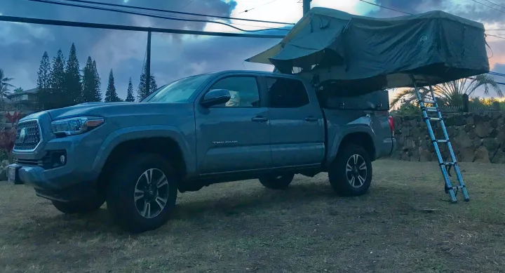 Grey pickup truck with a deployed rooftop tent and ladder, perfect for an **RV rental** adventure.. Other Other 2019
