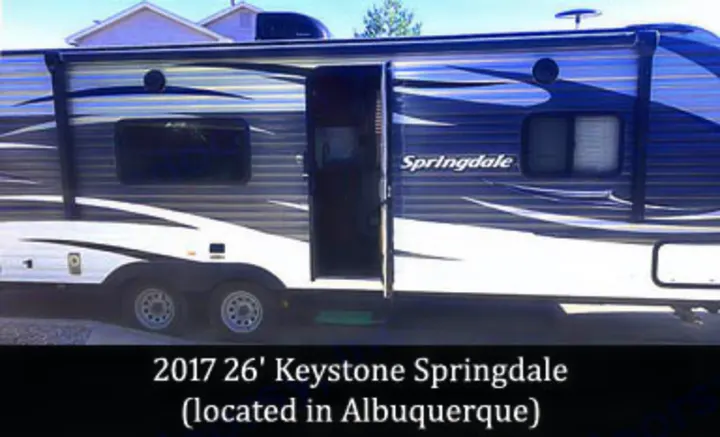 This 2017 26' Keystone Springdale travel trailer, with its door open, is perfect for an RV rental in Albuquerque.. Keystone Springdale 2017