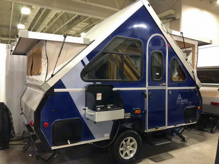 Blue A-Liner A-frame pop-up camper, a compact RV rental. Its unique top and side panels are partly extended.. A-Liner Classic 2019