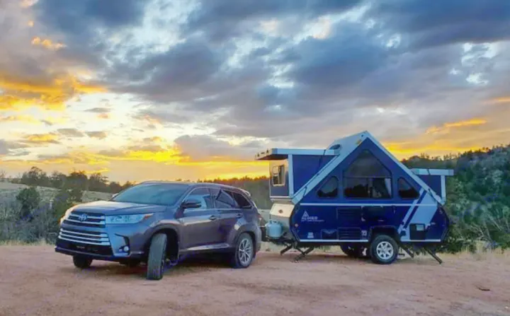 Beautiful sunset view with an SUV and A-frame pop-up camper, ideal for your next RV rental adventure.. A-Liner Classic 2019