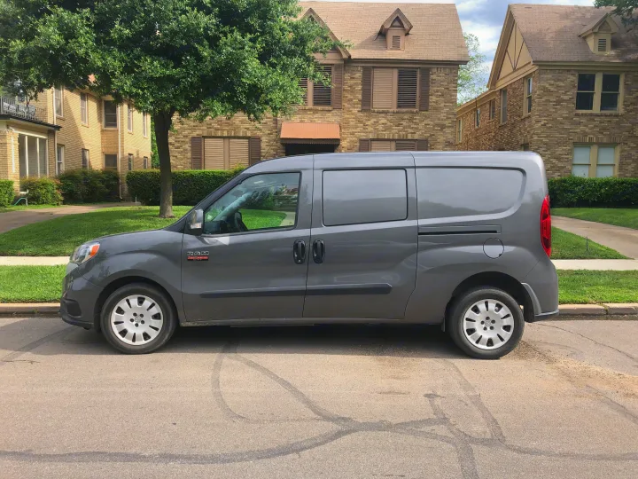A grey Ram ProMaster City van is parked on a residential street. Explore options beyond an rv rental.. ram promaster city 2016