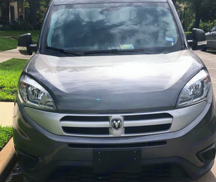 Front view of a modern grey van, excellent for an RV rental adventure or compact travel. Note the Ram logo and clear headlights.. ram promaster city 2016