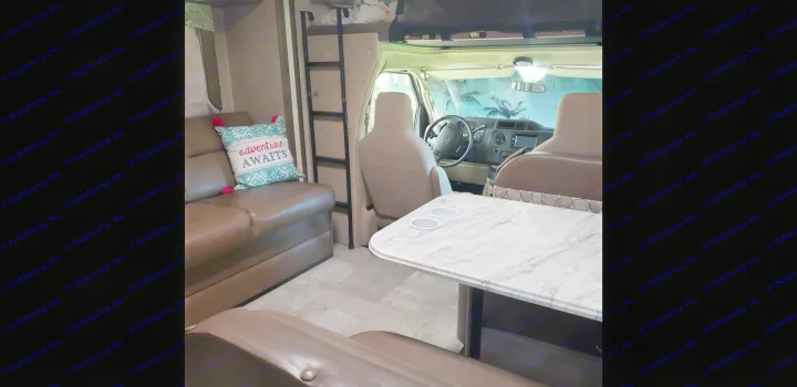 Spacious RV rental interior with a cozy dinette, modern cockpit, and inviting sofa. Adventure awaits!. Coachmen Freelander BH31 2019