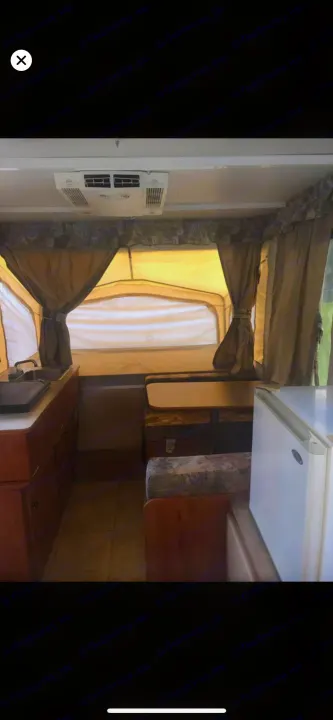 RV rental: Bright pop-up camper interior with kitchen, dining area, AC unit, & fabric walls.. Starcraft St 2006