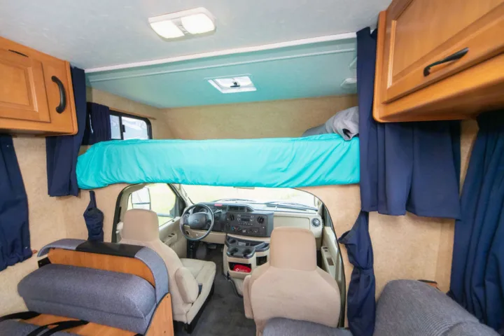 RV rental interior: an over-cab bunk bed, driver's cockpit, and overhead storage cabinets. Ready for your next adventure.. Other Other 2015