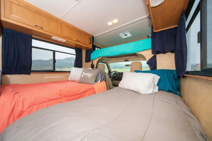 Spacious RV rental interior with two twin beds and an overhead bunk. Perfect for comfortable travel and scenic adventures.. Other Other 2015