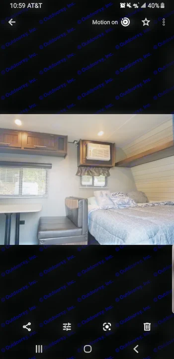 Cozy RV rental interior with a comfortable bed, dinette, and a window air conditioner unit mounted above for cooling.. Crossroads RV Zinger Lite 2019