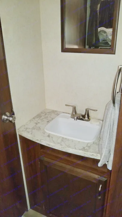 Functional bathroom in an RV rental, featuring a small sink, chrome faucet, mirror, and textured wallpaper.. Jayco Jay Flight 2018