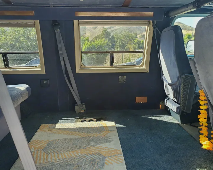 RV rental interior: Spacious back area with comfortable seating, dual windows offering scenic views, and soft carpeting.. Chevrolet Other 1989